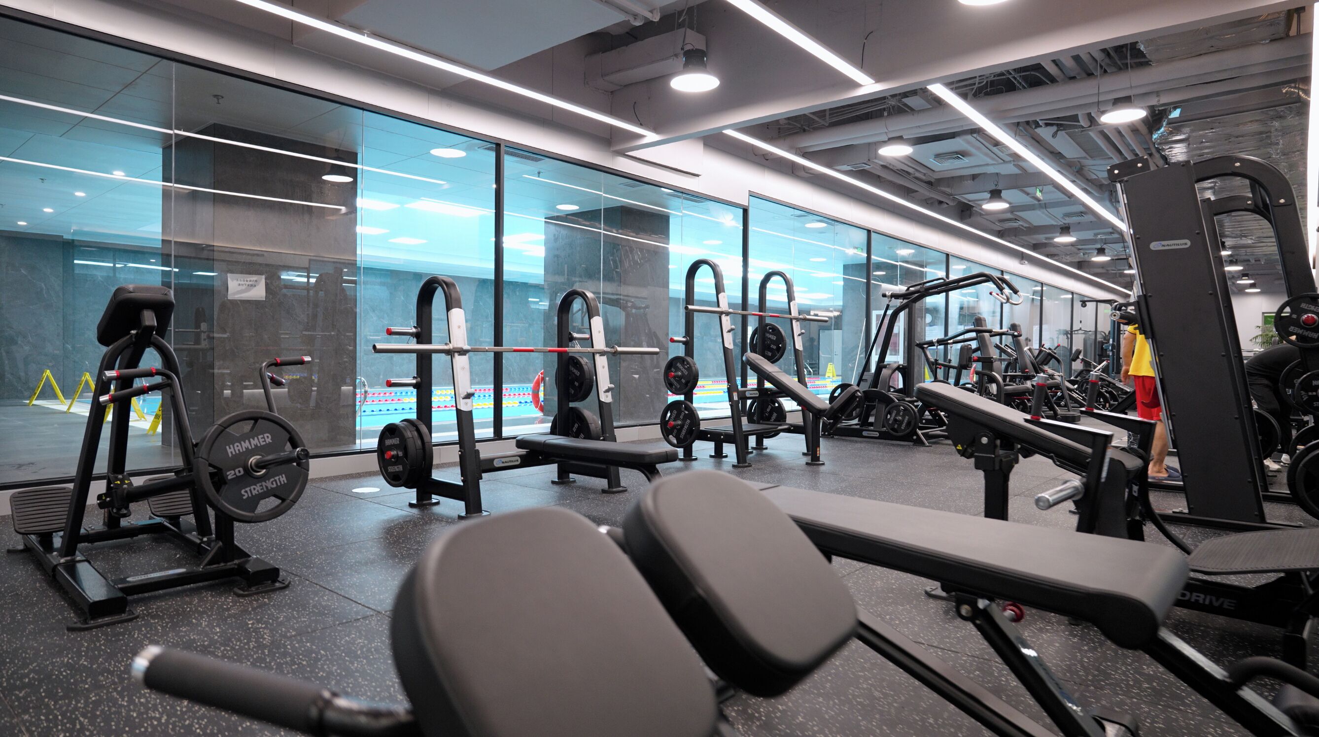 A gym with various exercise equipment, including treadmills, weight machines, and free weights.