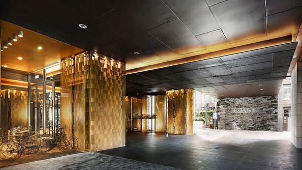 A spacious lobby with a modern design, featuring a large wooden column, a glass entrance, and a stone wall. - Artyzen Habitat Dongzhimen Beijing (Beijing)