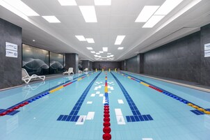 A swimming pool with lane dividers and lounge chairs.