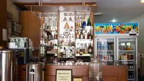 A bar area with a breakfast sign, a coffee machine, and a refrigerator stocked with beverages. - Stefans Guesthouse (Pattaya)