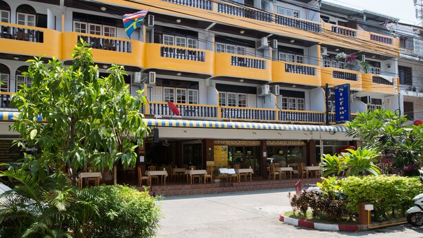 A multi-story hotel with balconies, outdoor seating, and a sign for 'Stefan's Guest House'. - Stefans Guesthouse (Pattaya)