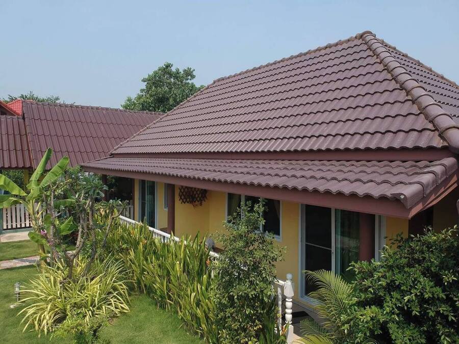 A two-story house with a tiled roof, a front porch, and a well-maintained garden.