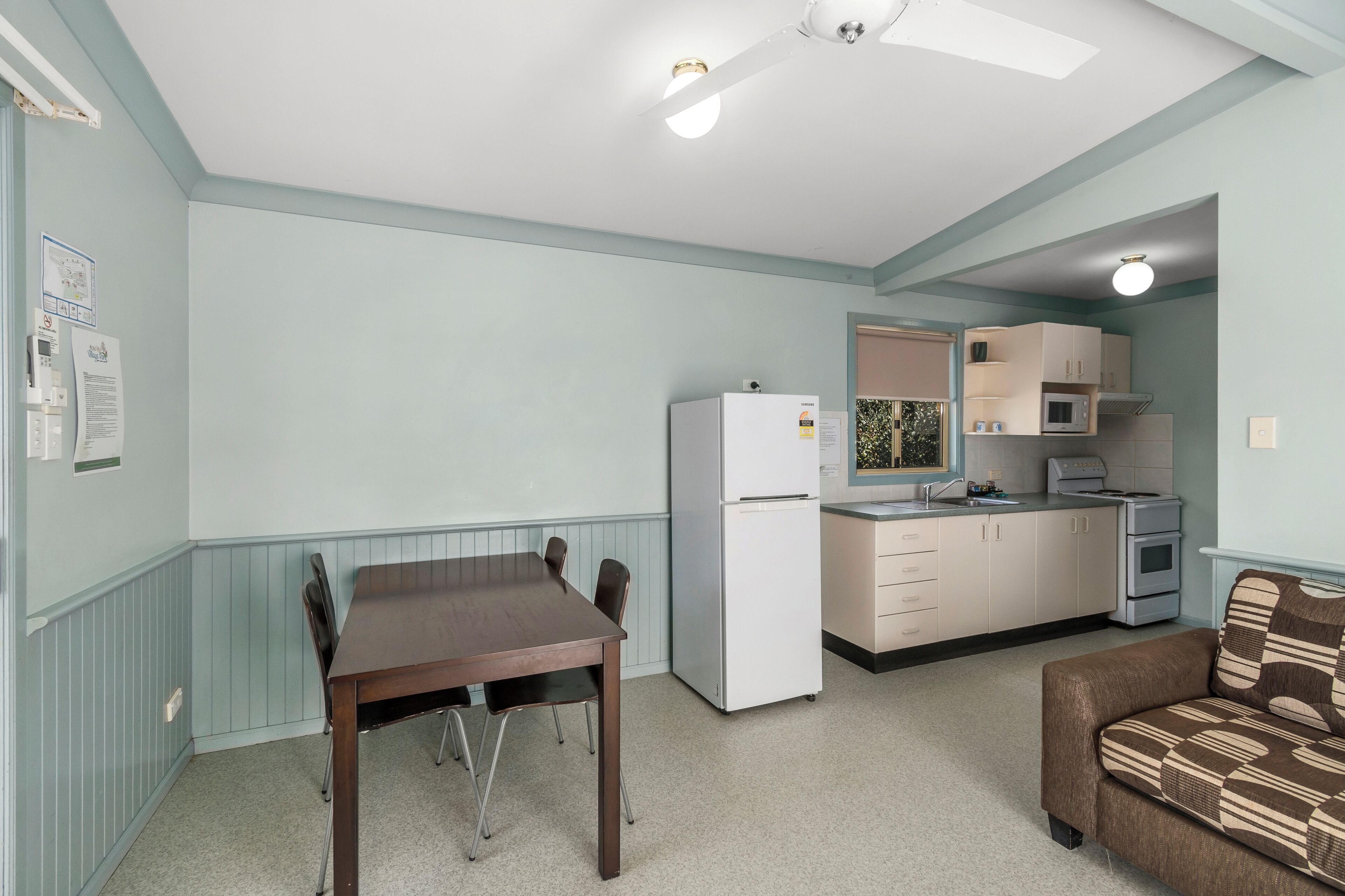 Una cocina compacta equipada con refrigerador, microondas y horno.