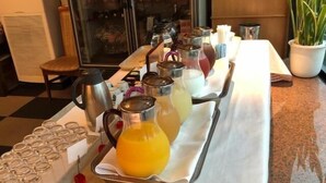 Un buffet proposant diverses boissons et une cafetière sur un plateau.