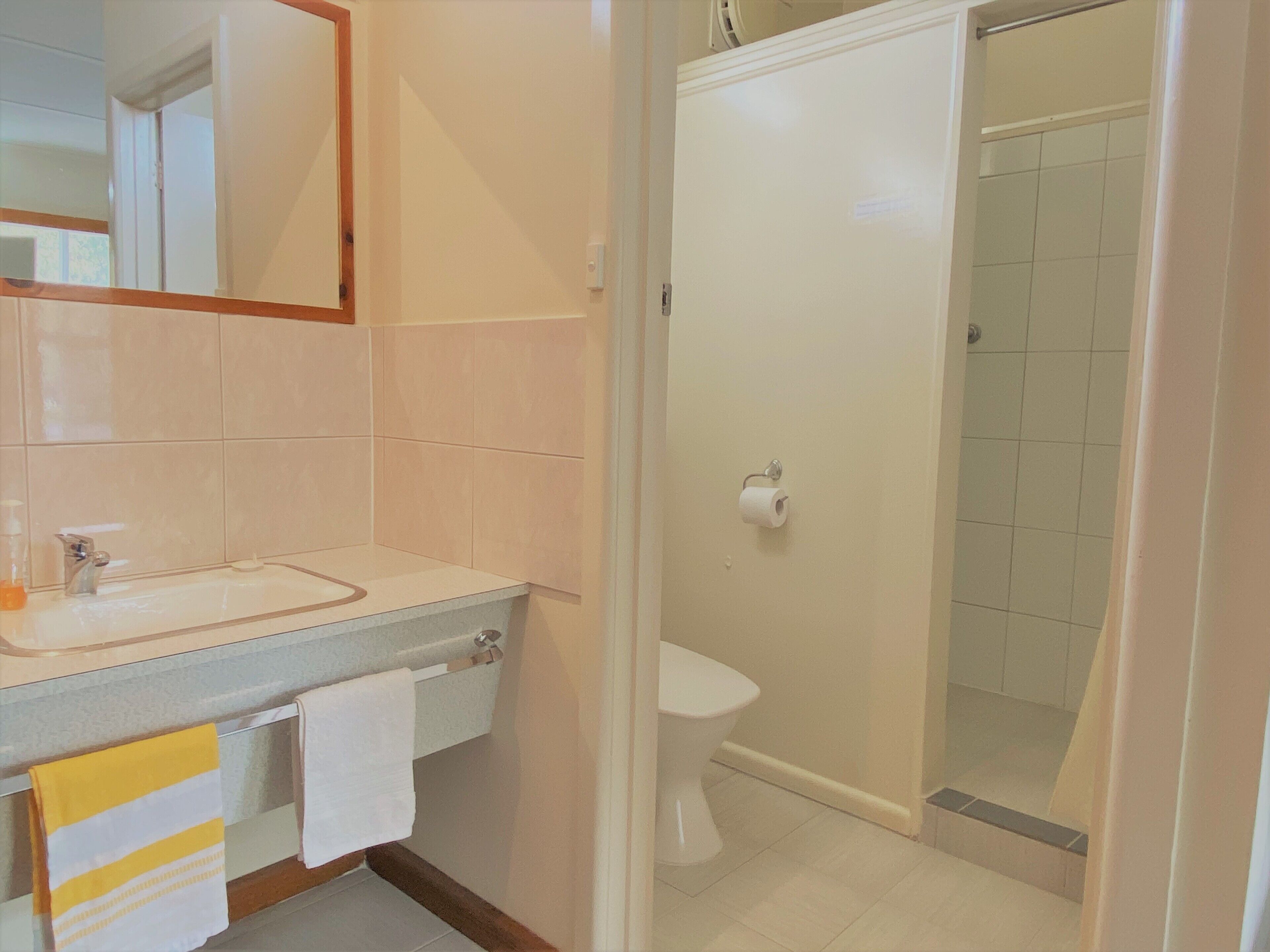 A bathroom with a sink, toilet, and shower.