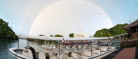 A boat docked at a pier with a rainbow in the background.