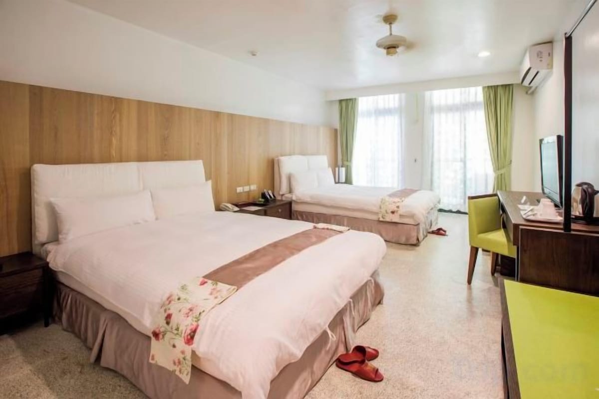Una habitación de hotel con una cama grande, un escritorio y una silla.