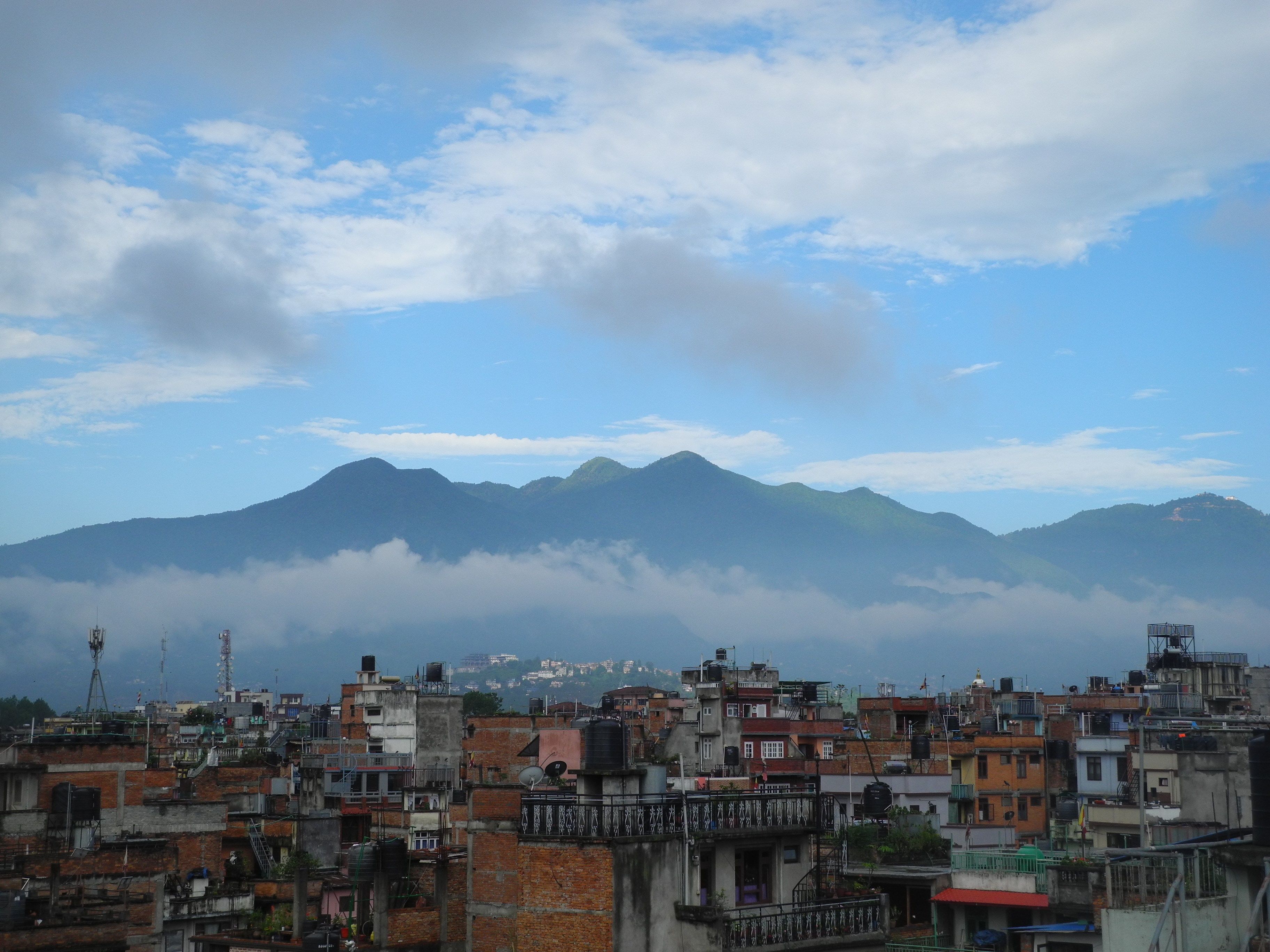 A mountainous landscape with a city in the foreground.