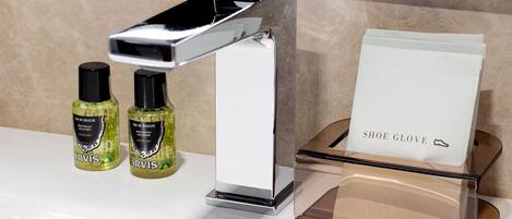 A modern bathroom with a chrome faucet, two bottles of hand soap, and a shoe glove holder.