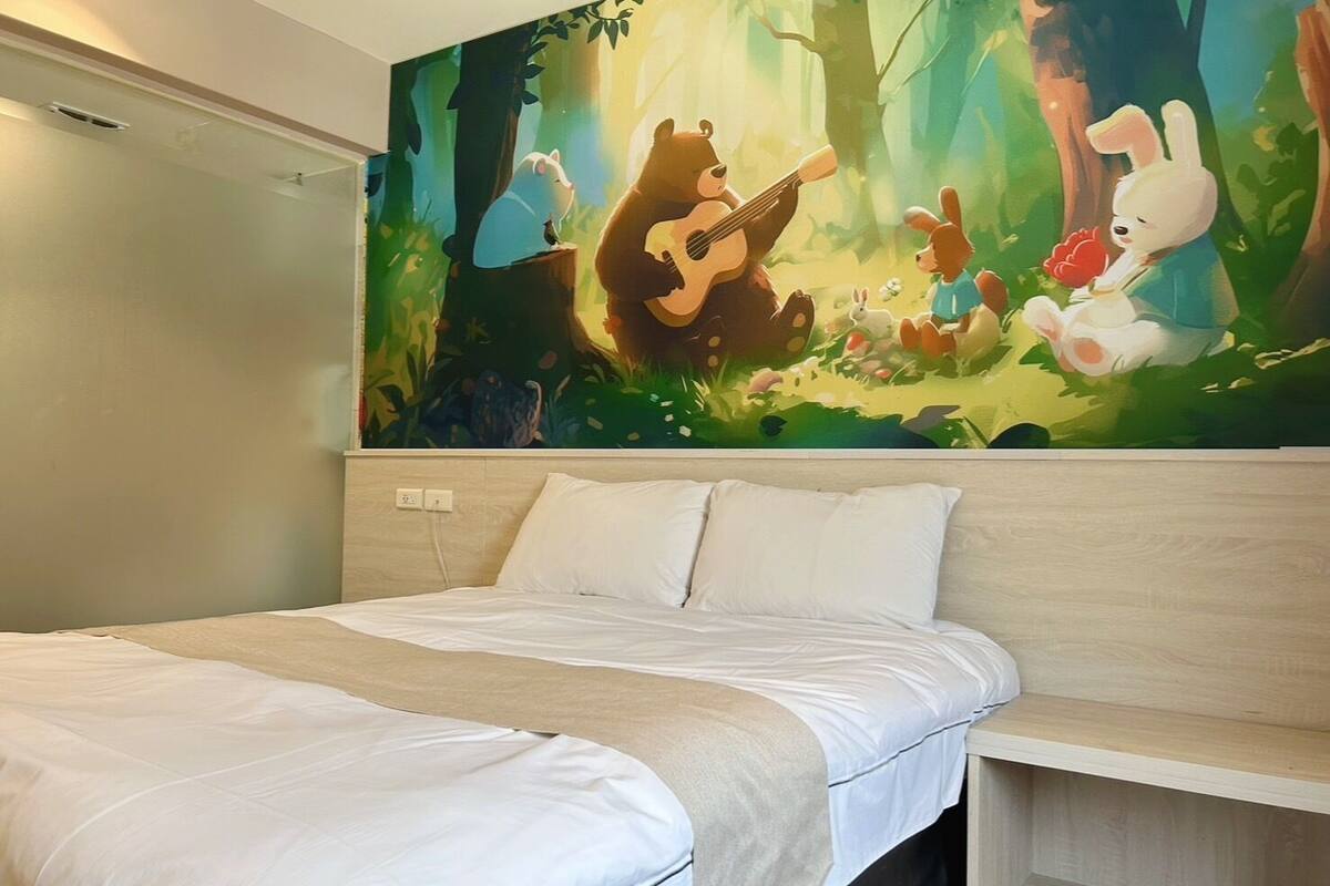 A bedroom with a bed, a headboard, and a large forest-themed mural on the wall.