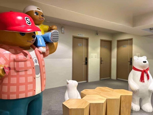 Eine Hotelhalle mit Empfangsbereich, Holzboden und einer Reihe von Türen.
