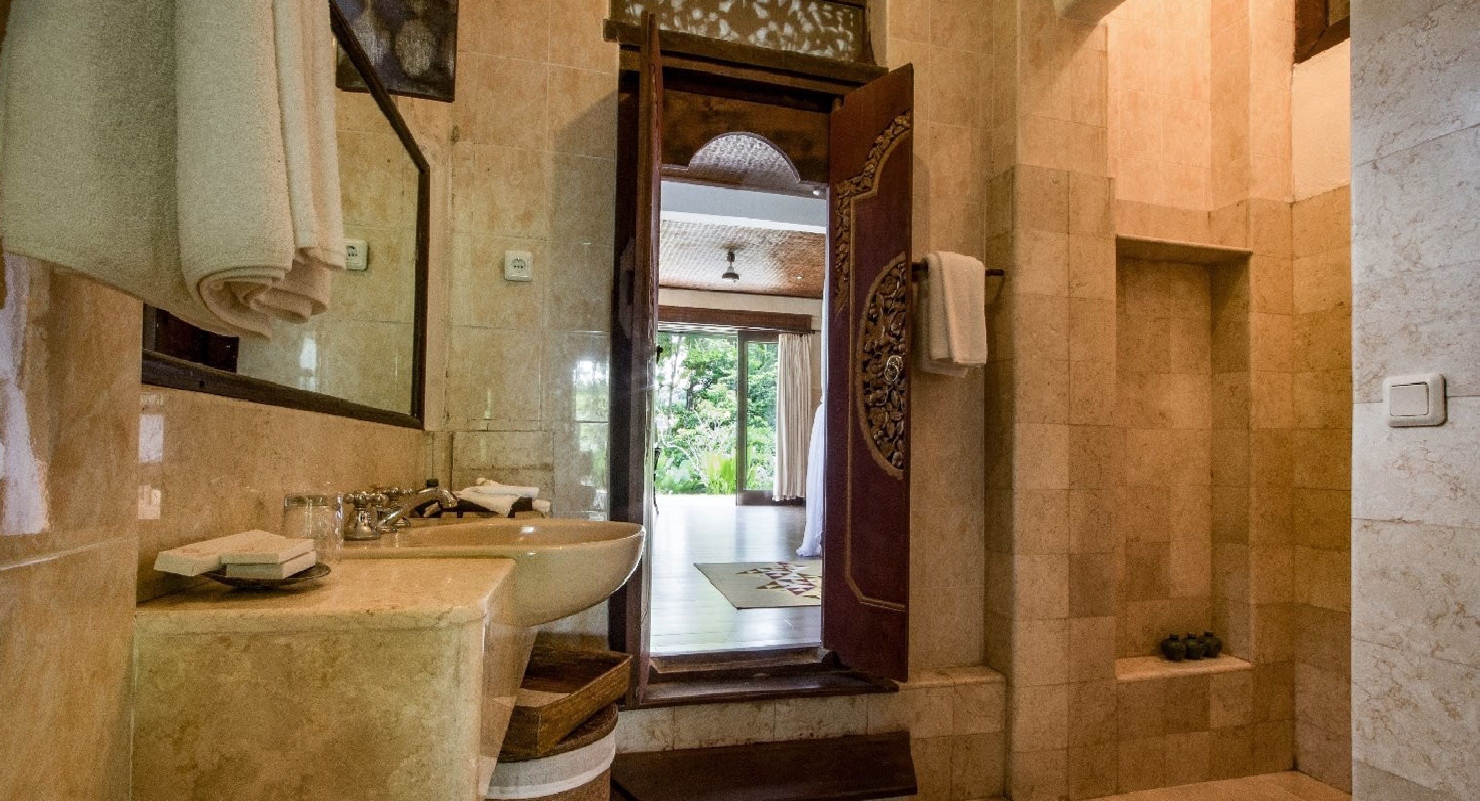 Un baño con un lavamanos grande, un espejo y una zona de ducha.