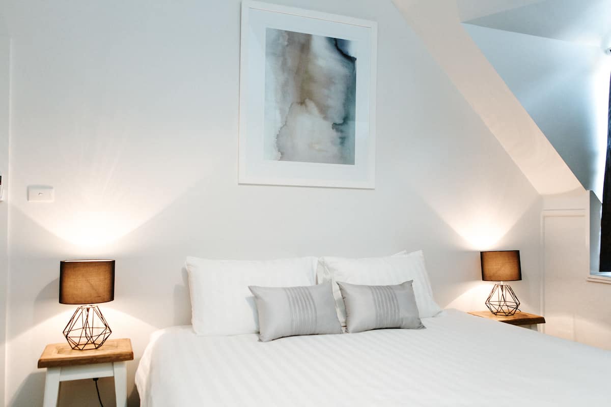 one or two bedroom king suite | premium bedding, desk, laptop workspace, iron/ironing board