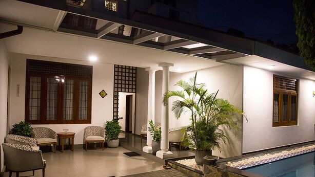 A covered outdoor area with a pool, seating, and potted plants. - Suriya Arana (Negombo)