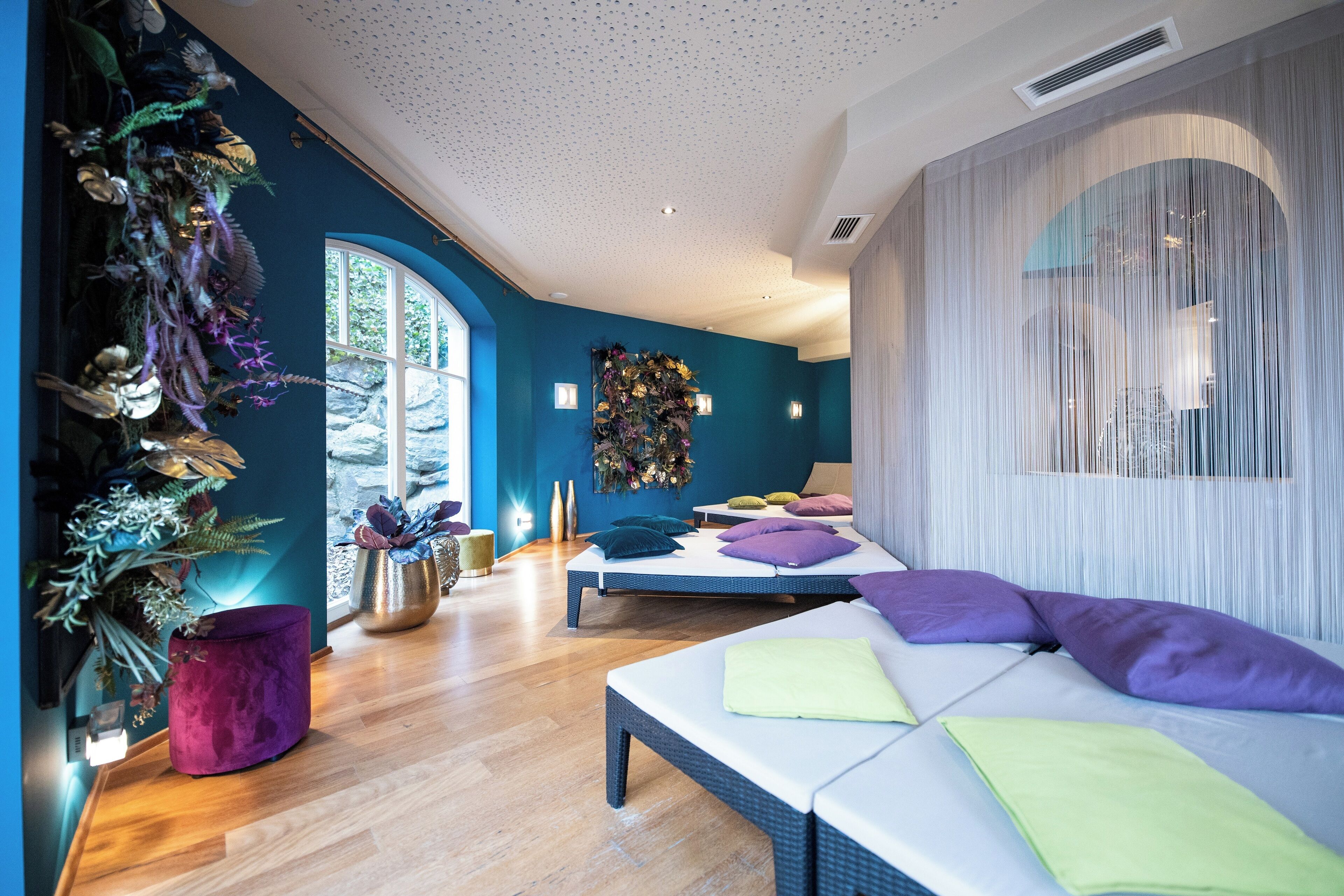 Ein modernes Schlafzimmer mit einem großen Bett, einer kleinen Sitzecke und einer dekorativen Wand.