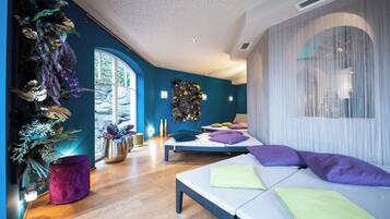 Ein modernes Schlafzimmer mit einem großen Bett, einer kleinen Sitzecke und einer dekorativen Wand.