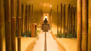 A corridor with a central seating area, flanked by bamboo structures and plants. - Maiers Kuschelhotel deluxe - Adults only (Jennersdorf)
