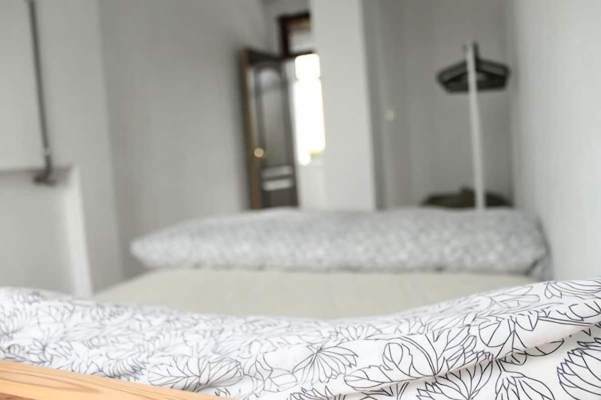 A bedroom with a bed, a bedside table, and a wardrobe.