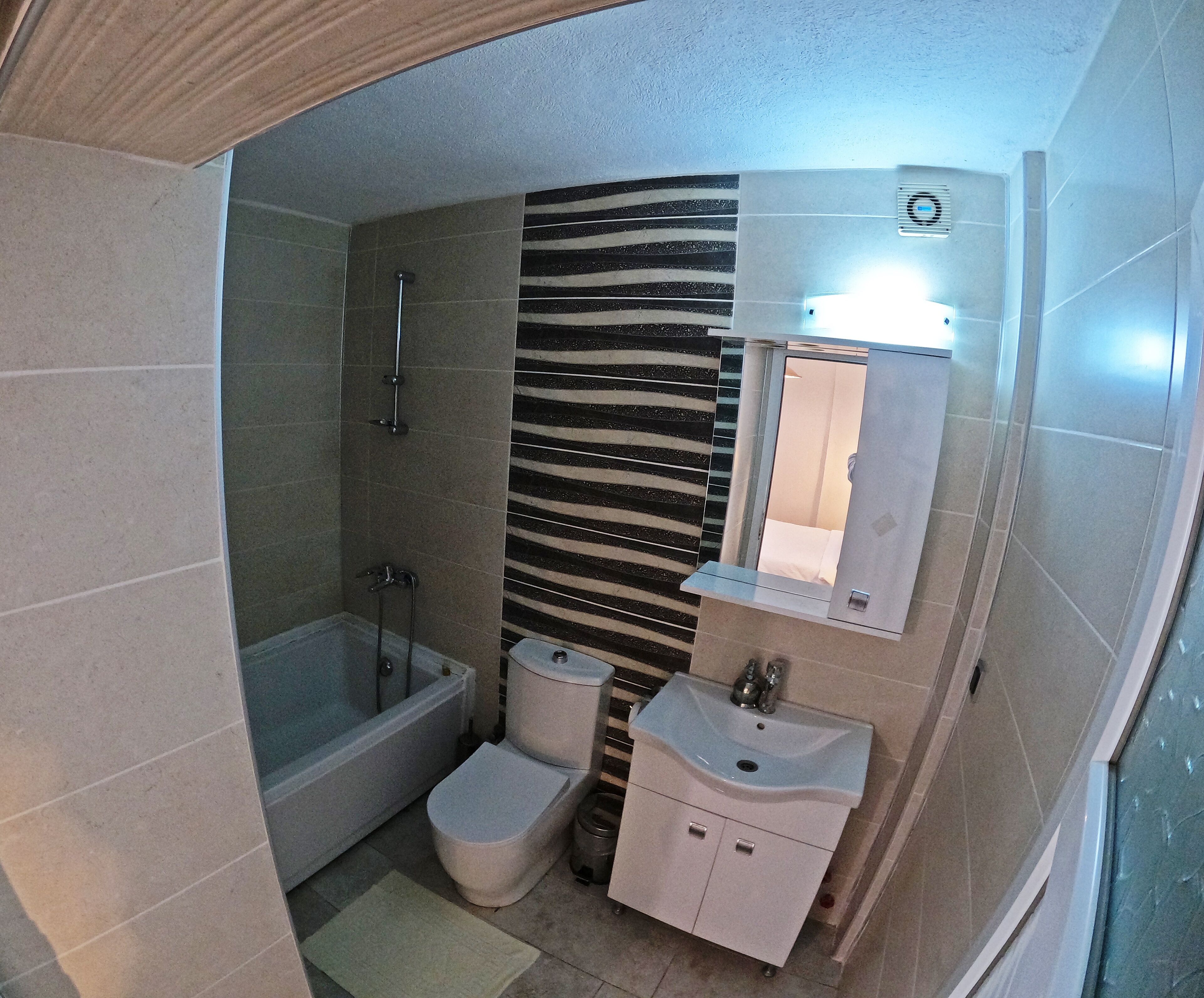 A compact bathroom with a shower, toilet, and sink.