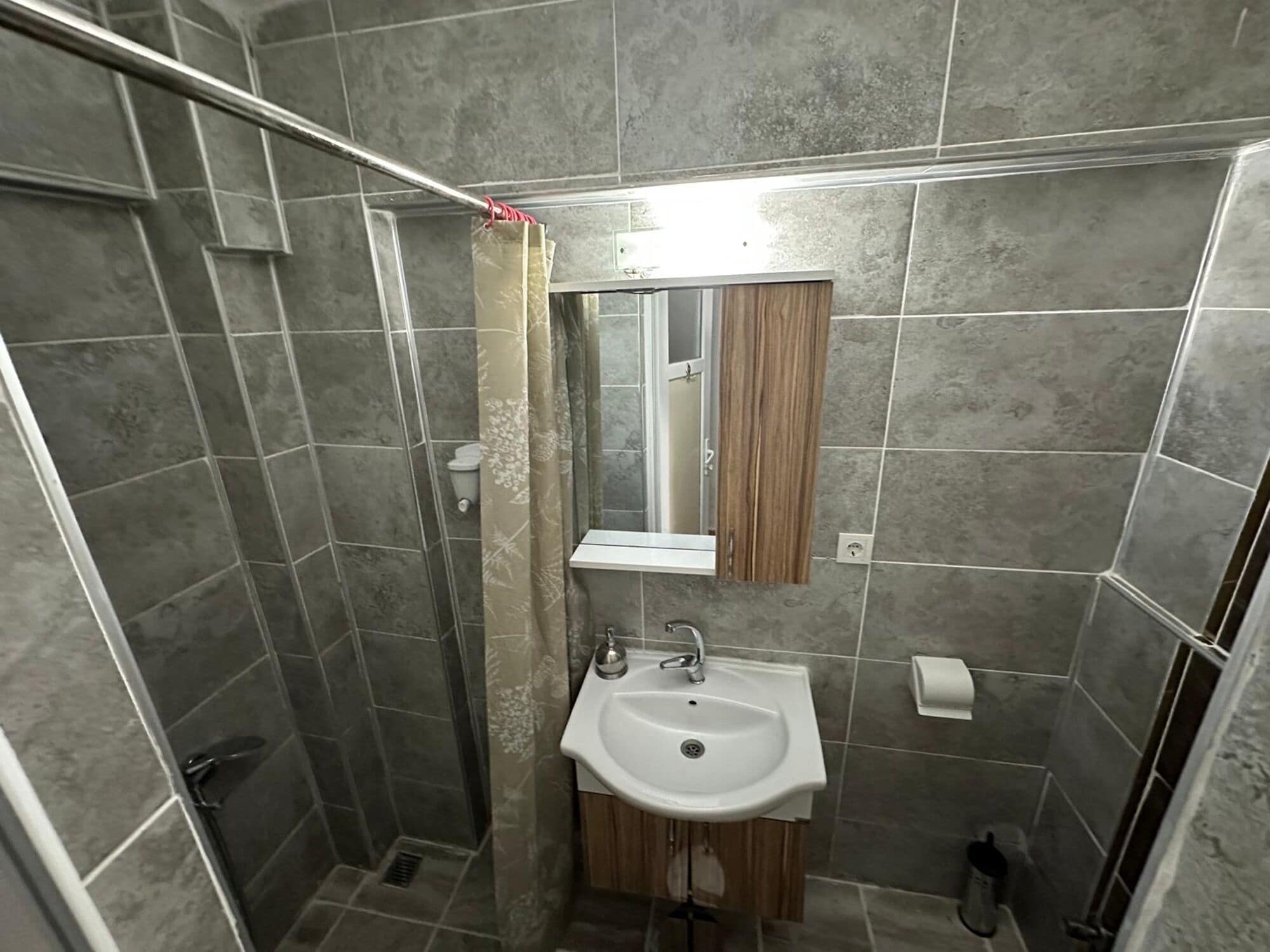 Une petite salle de bain avec une douche, un lavabo et des toilettes.