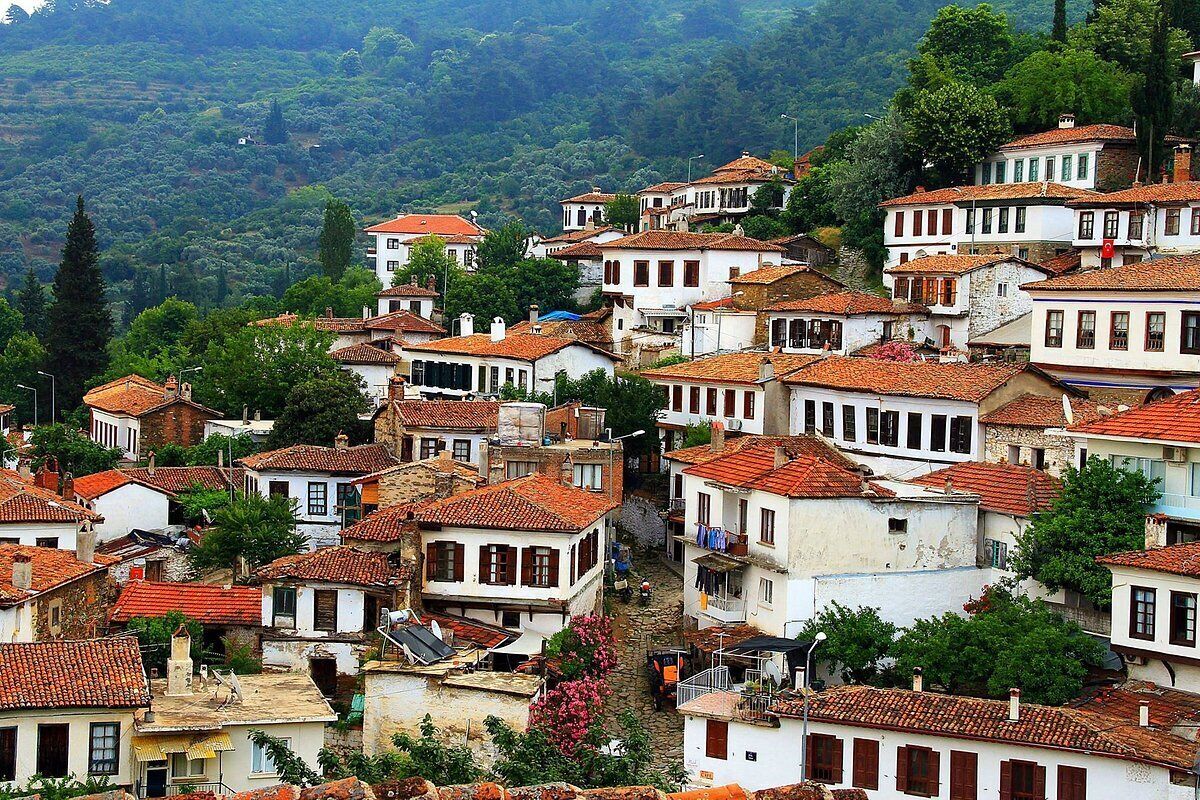 Un pueblo en la ladera con arquitectura tradicional, calles estrechas y casas escalonadas.