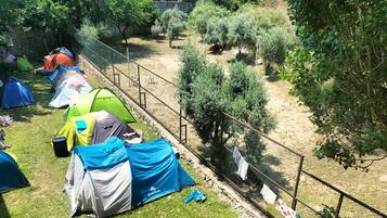 Un camping con varias tiendas de campaña y una zona delimitada por una valla.