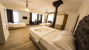 A hotel room with two beds, a sitting area with a table and chairs, and a large mirror. - Atilla's Getaway (Selçuk)
