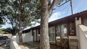 A building with a white exterior, large windows, and a patio area with a table and chairs. - Atilla's Getaway (Selçuk)