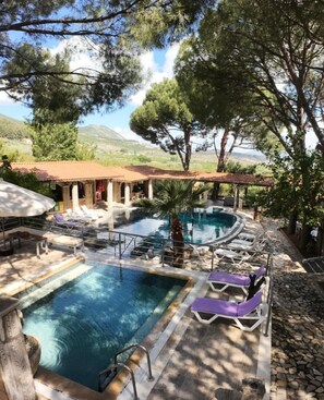 A pool area with multiple pools, lounge chairs, and a covered seating area. - Atilla's Getaway (Selçuk)