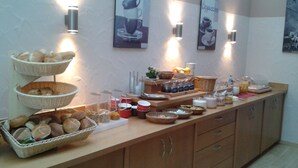 A buffet setup with bread baskets, condiments, and beverages. - Hotel Gasthof Hereth (Wirsberg)