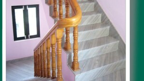 A staircase with wooden balusters and a pink wall. - Le Rhododendron Chambres D'hotes (Kathmandu)