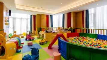A children's play area with a ball pit, colorful play structures, and toys.