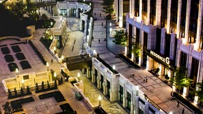 A hotel with a grand entrance, a spacious courtyard, and a modern building facade.