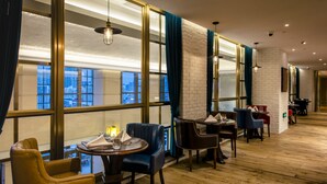 A modern hotel lobby with large windows, leather seating, and wooden flooring. - Residence G Shenzhen (Shenzhen)