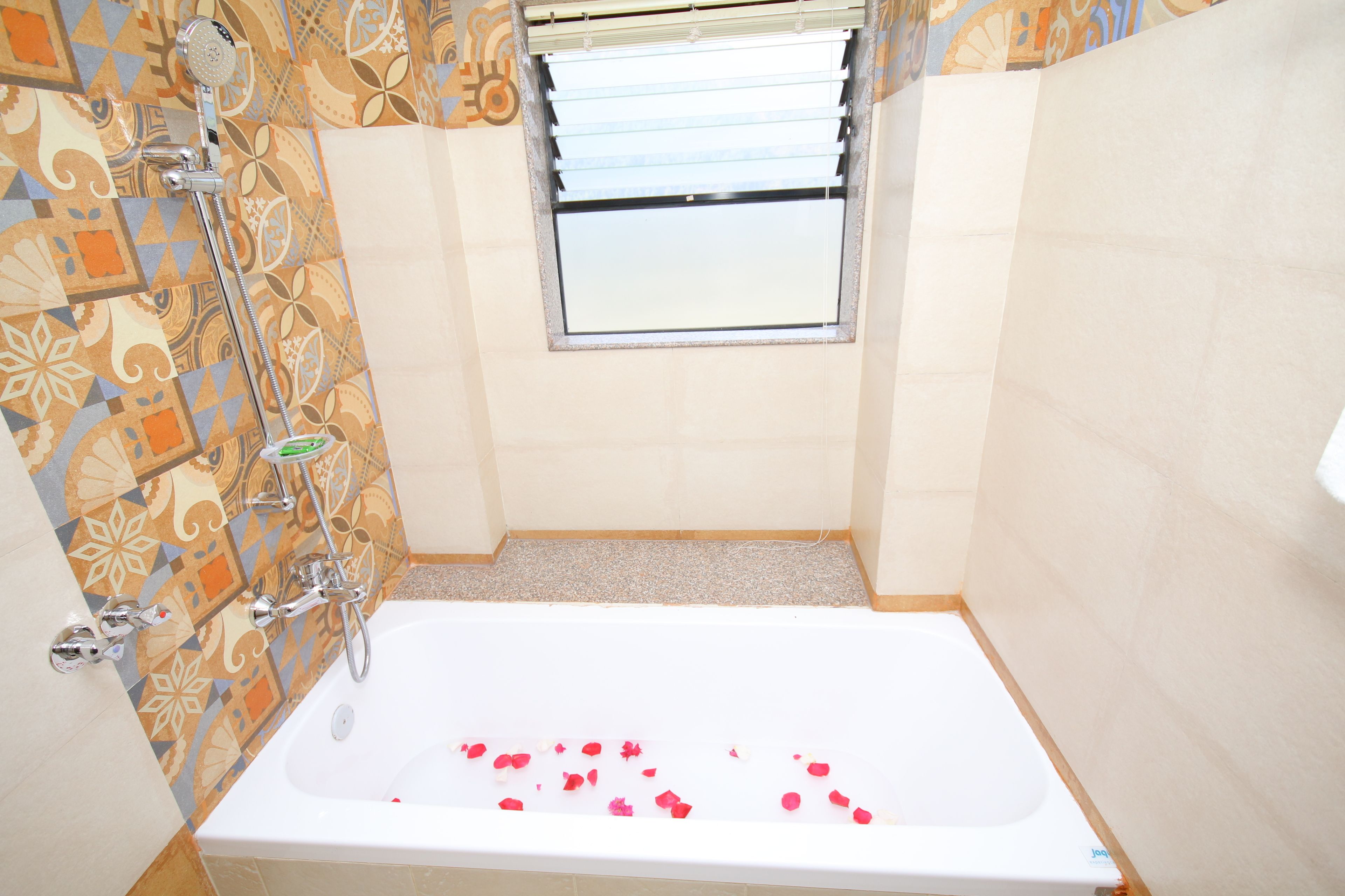 A bathroom with a bathtub, shower, and a window.