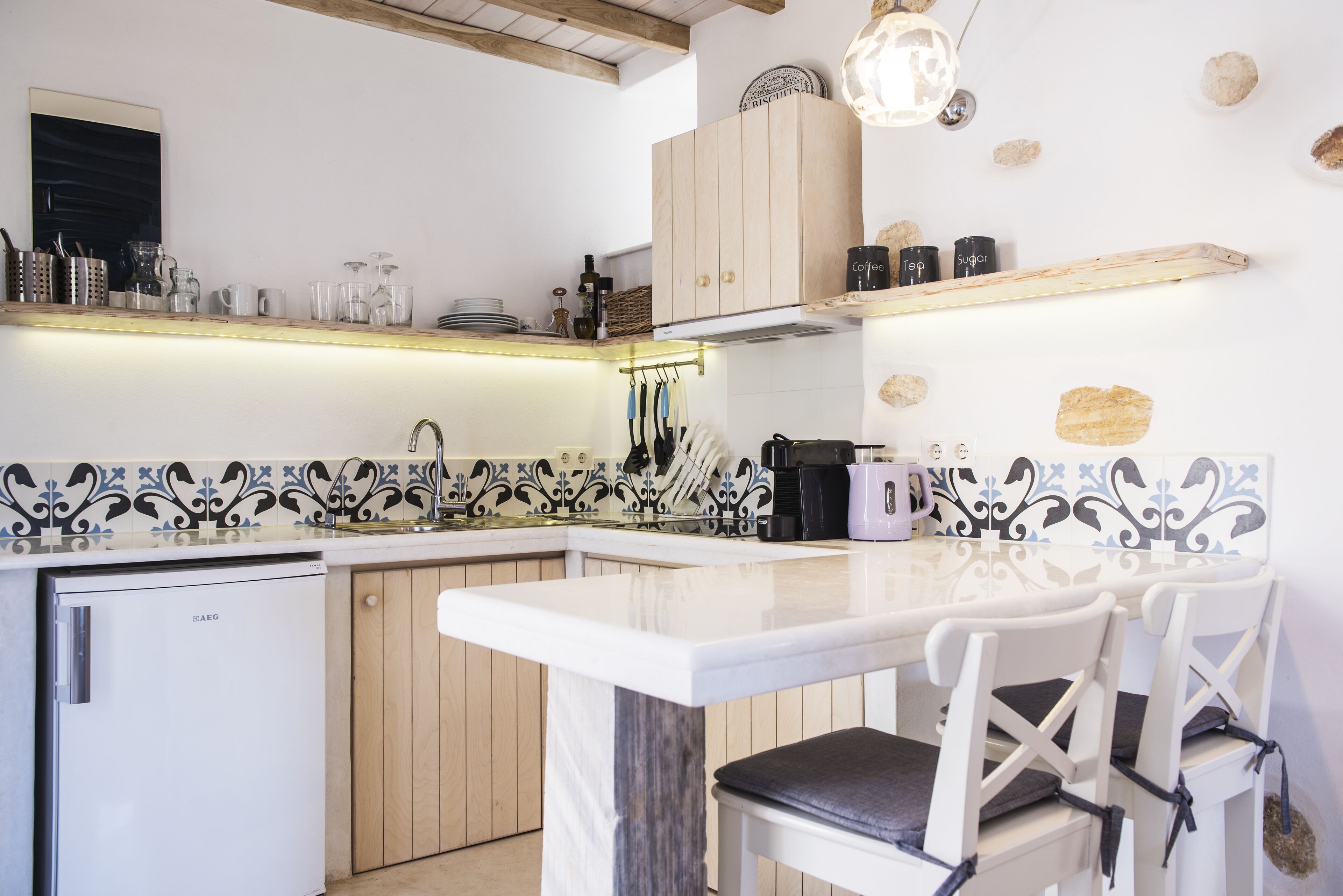 A modern kitchen with a built-in refrigerator, wooden cabinets, and a white countertop.