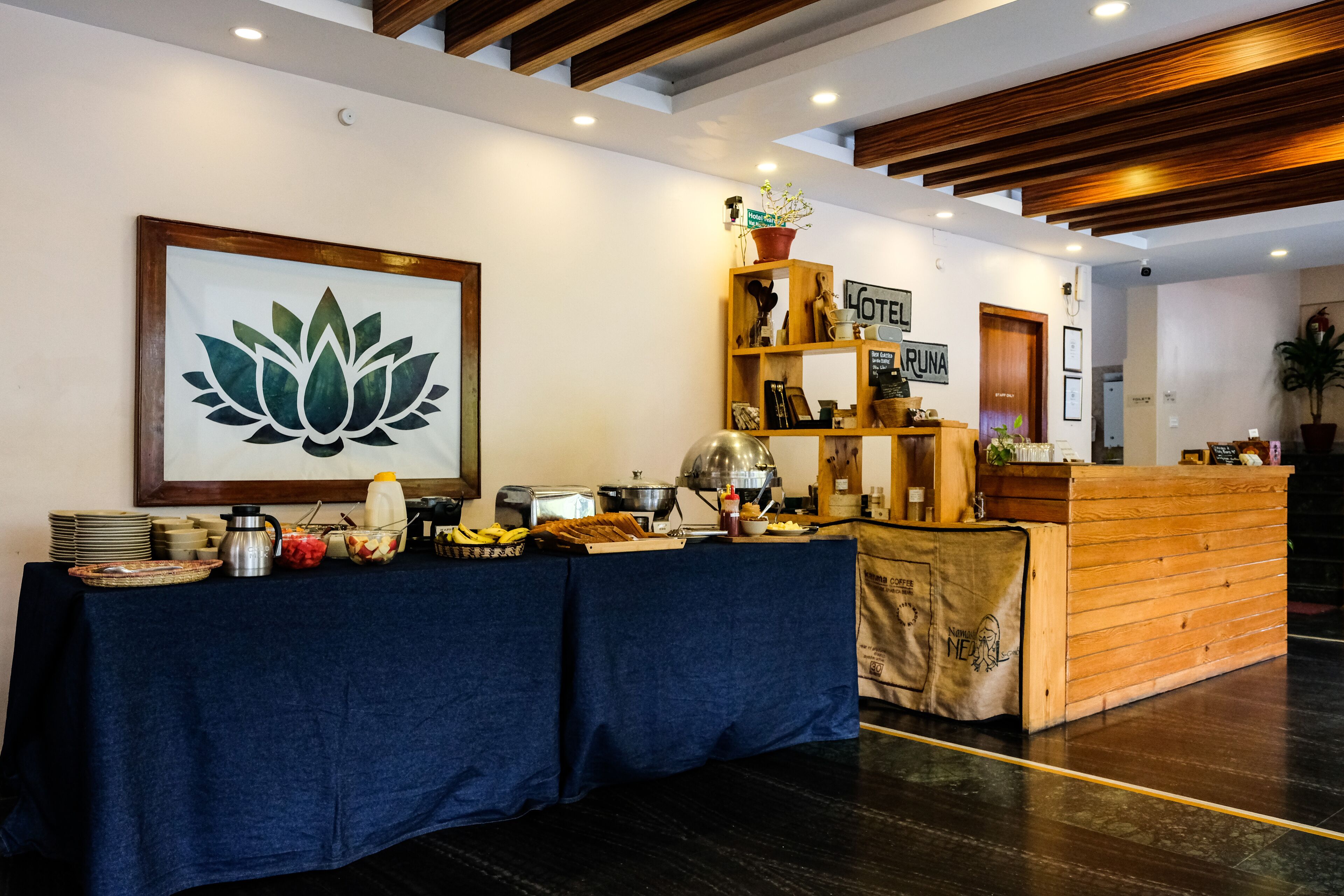 A reception area with a reception desk, a coffee station, and a wall-mounted sign.