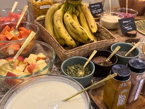 A breakfast buffet with various fruits, grains, and spices. - Hotel Karuna (Pokhara)