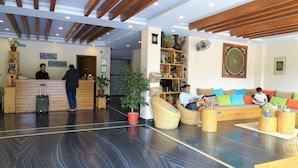 A hotel lobby with a reception desk, a sofa area, and a reception counter. - Hotel Karuna (Pokhara)