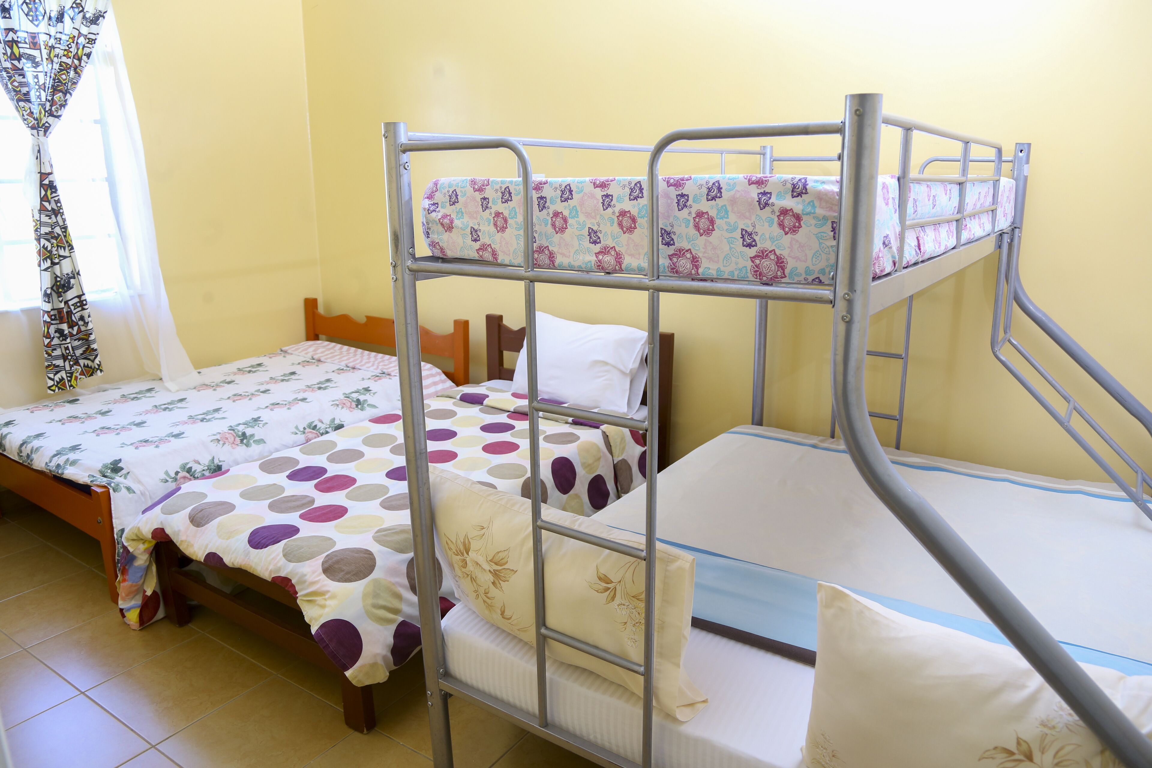 A bunk bed room with two beds, each with floral-patterned bedding.