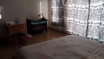 Relax in a spacious bedroom with a large bed, wooden chair, and small table.