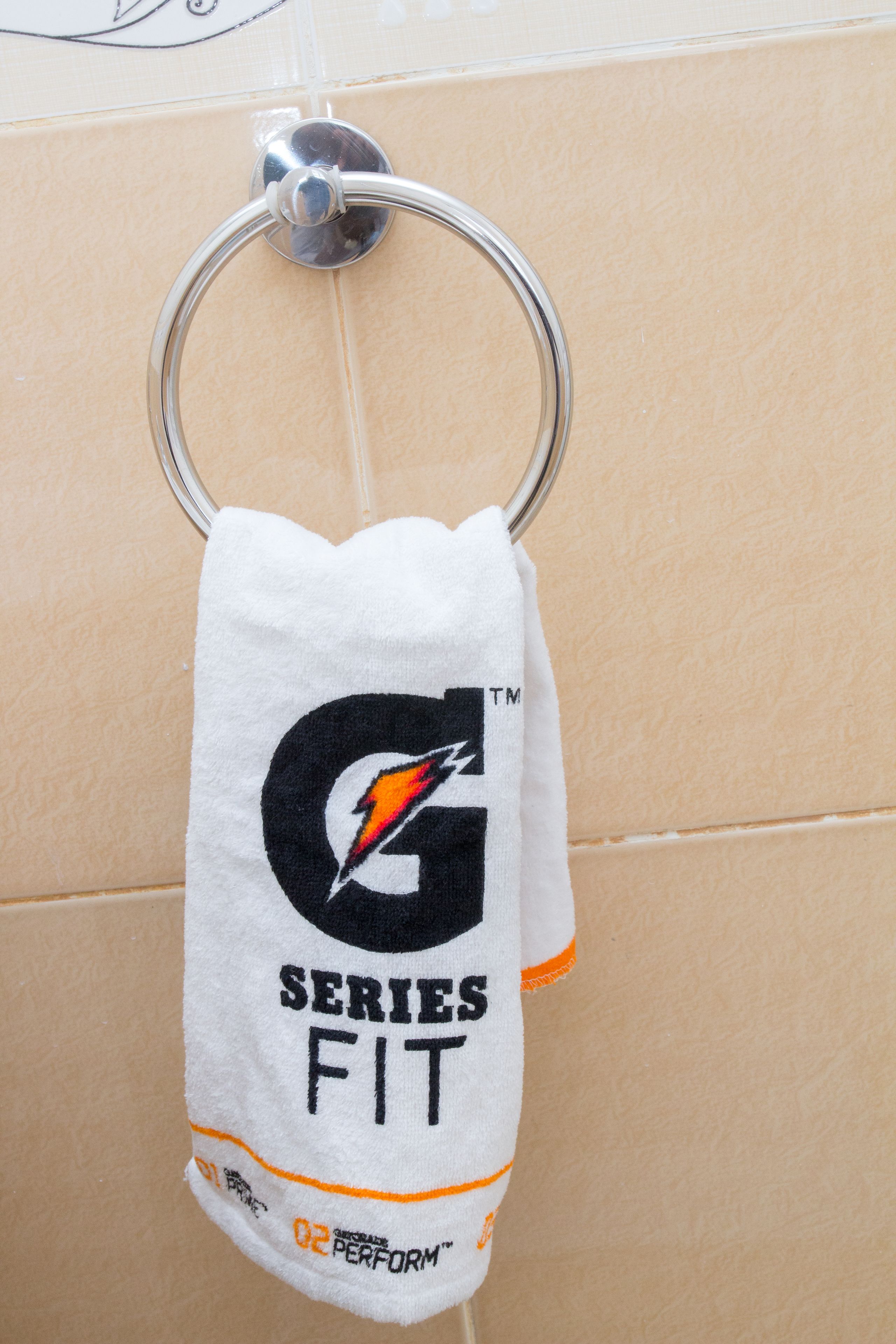 A towel hanging on a metal ring, with a logo and text indicating it is branded for a sports team.