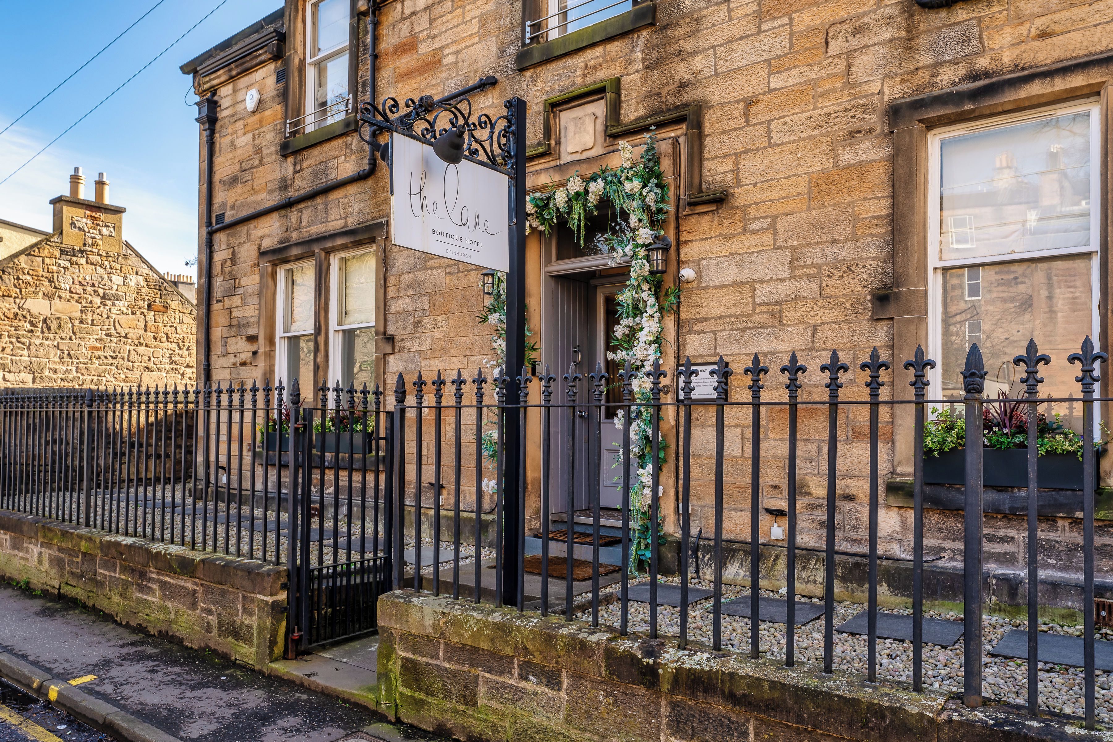 Un edificio de piedra con un letrero que dice 'The Lane Boutique Hotel' en Edimburgo.