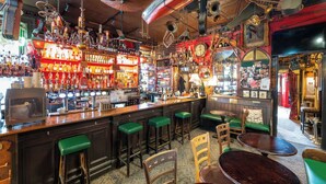 A bar with wooden stools, a bar counter, and various bottles. - The Lane Hotel (Edinburgh)