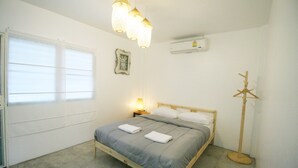 A bedroom with a bed, bedside lamp, and a floor lamp. - Hello Hostel Pakchong (Pak Chong)