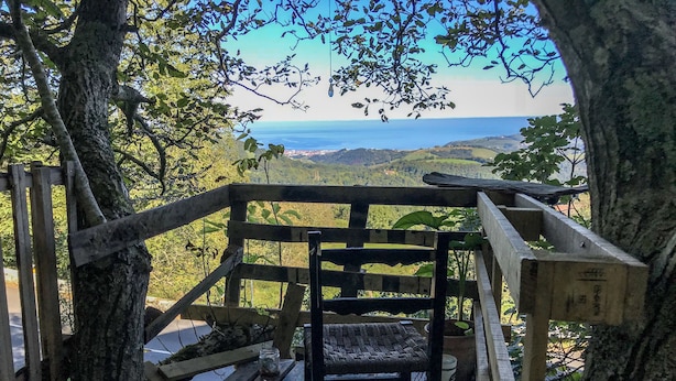 A wooden bench with a view of a coastal landscape. - Surf Camp San Sebastian Partyhostel (Aia)