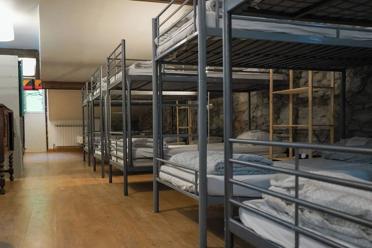 Bunk beds in a room with stone walls and a wooden floor.
