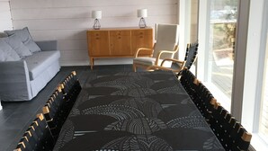 Un salon moderne avec une longue table à manger, un canapé, un meuble en bois et une chaise.