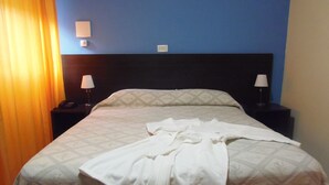 A hotel room with a bed, two bedside lamps, and a telephone on the nightstand. - Complejo Rumipal (Villa Rumipal)
