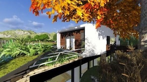 A modern house with a glass facade, surrounded by a garden and a body of water. - Quinta do Pomar Maior (Arouca)